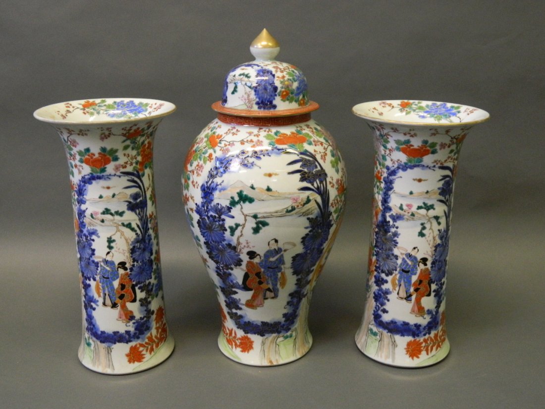 A good C19th Japanese garniture of three vases painted: A good C19th Japanese garniture of three vases painted in blue, red and green, with figures and birds, signed to base, 20'' high