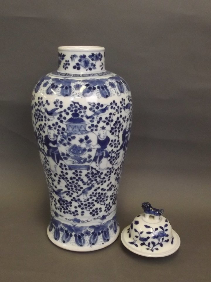 A Chinese blue and white baluster vase decorated with: A Chinese blue and white baluster vase decorated with boys holding a large vase within a butterfly border, and a blue and white lid, 12½'' high