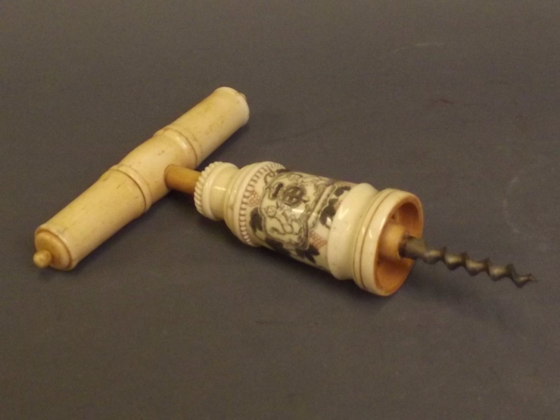 A carved bone corkscrew decorated with a coat of arms: A carved bone corkscrew decorated with a coat of arms and fruiting vines, 7'' long
