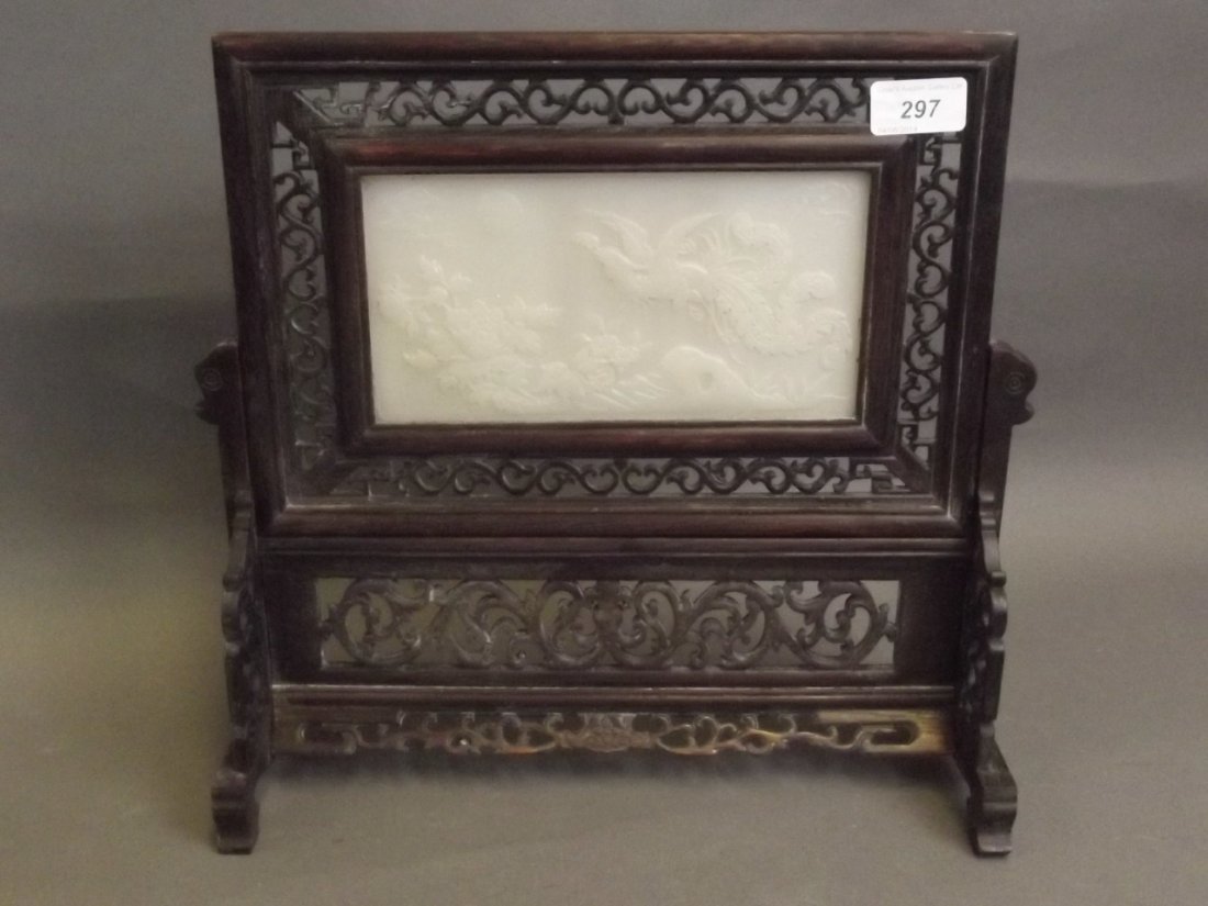 A Chinese white jade and carved hardwood table screen: A Chinese white jade and carved hardwood table screen with carved phoenix and floral decoration, character inscription verso, 13¼'' high, 14'' wide