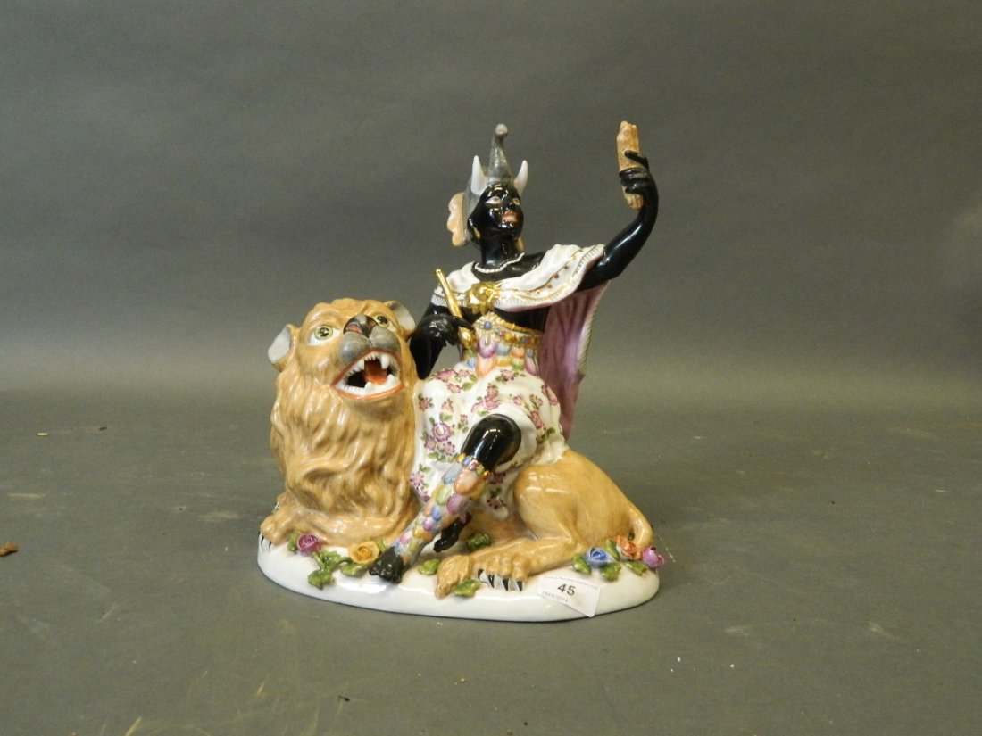 A porcelain figure of a Negress sitting on a lion, 12'': A porcelain figure of a Negress sitting on a lion, 12'' high