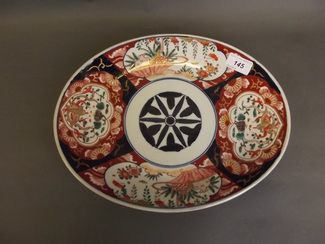 A C19th Japanese Imari oval platter painted with: A C19th Japanese Imari oval platter painted with baskets, phoenix etc, 13'' x 10''