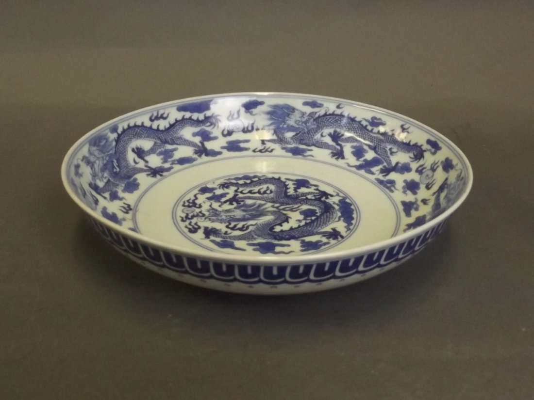 A Chinese blue and white porcelain bowl decorated with: A Chinese blue and white porcelain bowl decorated with dragons chasing the flaming pearl, 6 character mark, 8¼'' diameter