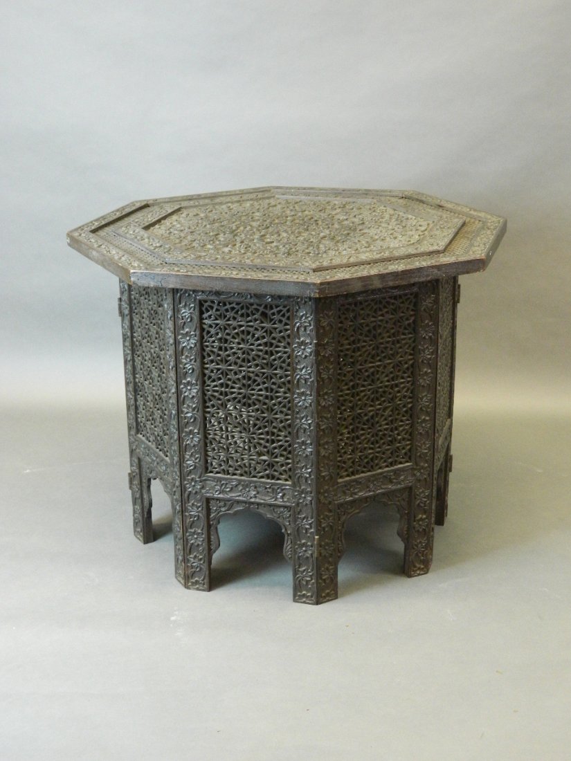 A C19th Indian octagonal carved and pierced hardwood: A C19th Indian octagonal carved and pierced hardwood centre table on a folding base, 30½'' diameter, 24'' high