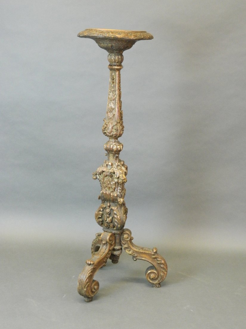 An early C18th Italian carved lime wood and gilt: An early C18th Italian carved lime wood and gilt decorated torchere on three supports, 41½'' high