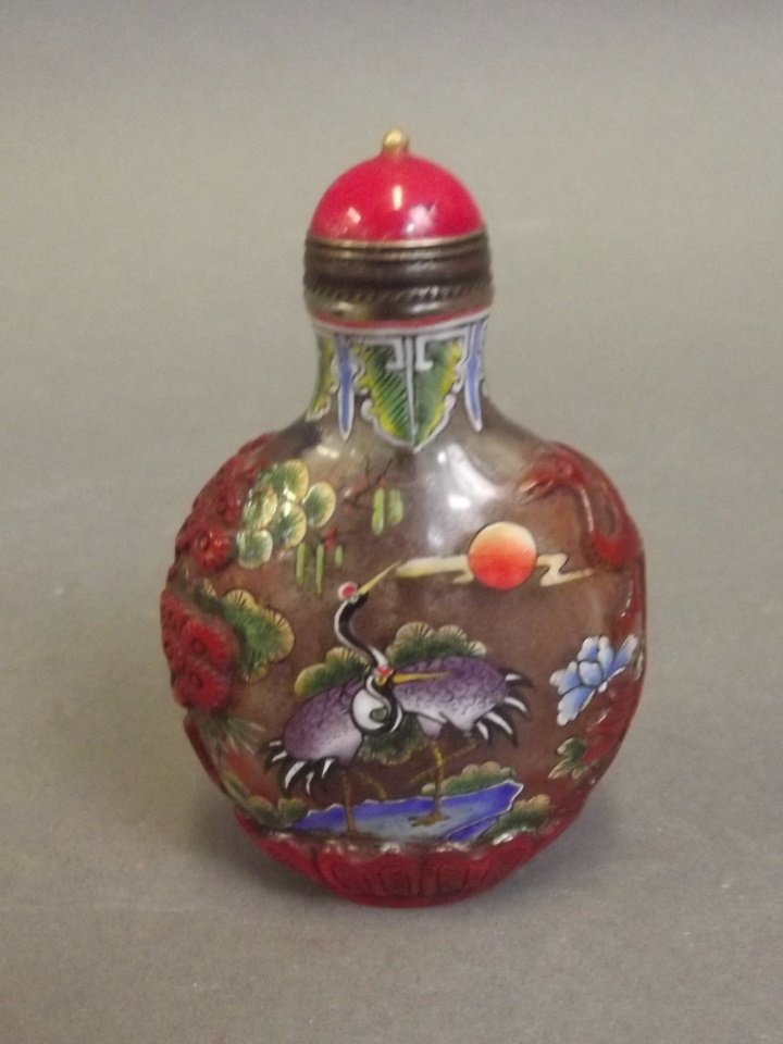 A Peking glass snuff bottle with painted enamel: A Peking glass snuff bottle with painted enamel decoration of an exotic bird, 4 character mark, 2¾'' high