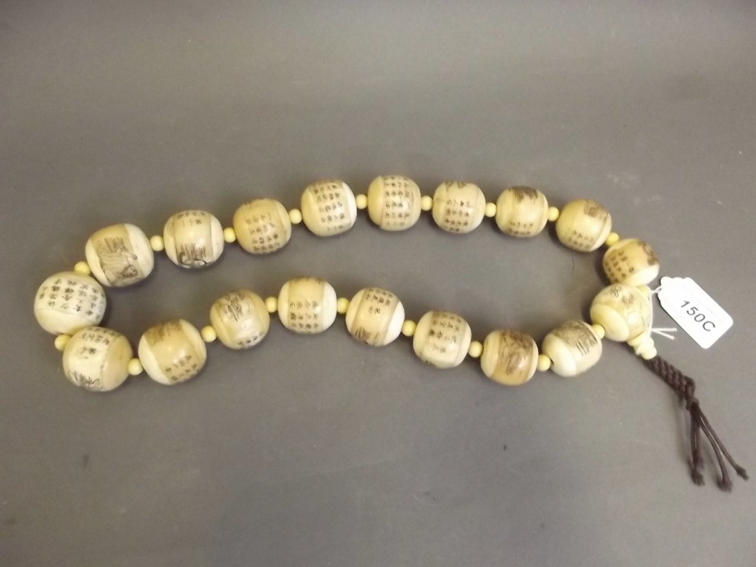 A faux ivory and bone bead necklace decorated with: A faux ivory and bone bead necklace decorated with calligraphy etc, beads 1¼'' diameter