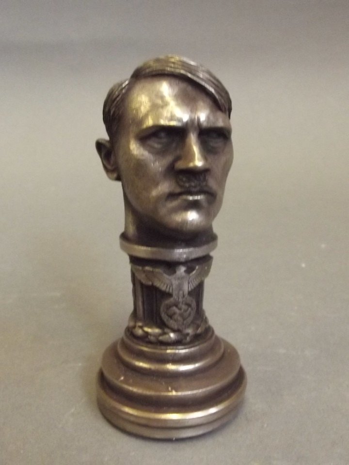 A silvered metal desk seal decorated with an Imperial: A silvered metal desk seal decorated with an Imperial eagle and swastika, with a knop in the form of Hitler's head, 3'' high