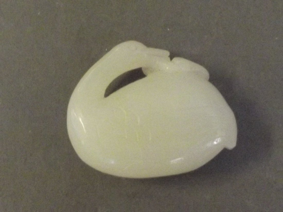 A Chinese jade carved ornament in the form of a resting: A Chinese jade carved ornament in the form of a resting duck, 2'' wide