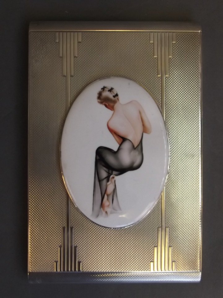 A silver engine turned cigarette case with later: A silver engine turned cigarette case with later applied cold enamel plaque depicting a lady in an open back dress in the style of Varga, London 1949, 3½'' x 5''