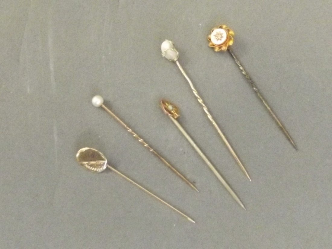 Five gold stick pins set with various stones to include: Five gold stick pins set with various stones to include pearls, 1¾'' long