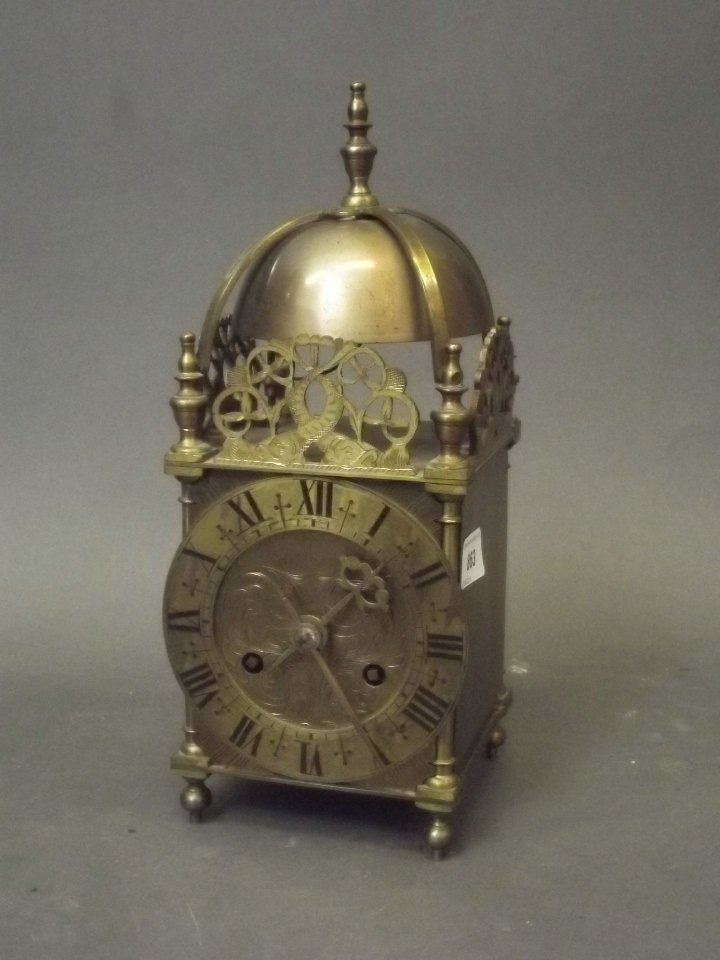 A late C19th/early C20th brass lantern clock with: A late C19th/early C20th brass lantern clock with engraved dial and pierced crest with dolphin decoration, 5'' square, 12½'' high