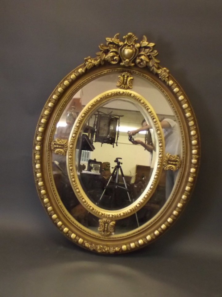 A large circular gilt sectional wall mirror, 54'' high: A large circular gilt sectional wall mirror, 54'' high