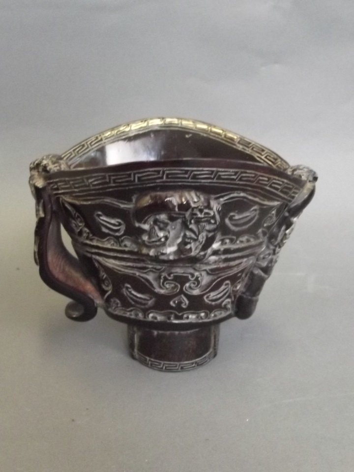 A Chinese carved horn libation cup with dragon and: A Chinese carved horn libation cup with dragon and kylin decoration, 5'' high