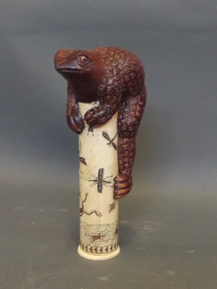 An Oriental bone document holder with etched decoration: An Oriental bone document holder with etched decoration of pond life and a toad knop, 7¼'' high