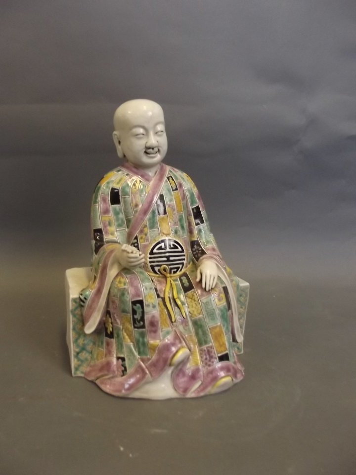 An early C20th Chinese famille verte pottery seated: An early C20th Chinese famille verte pottery seated figure holding beads, 10'' high
