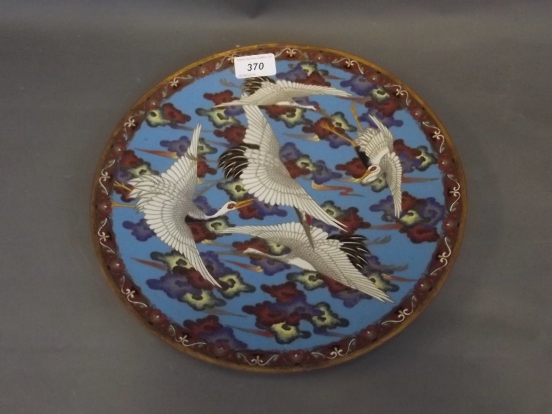 A good C19th Japanese cloisonné charger decorated with: A good C19th Japanese cloisonné charger decorated with cranes in flight, 12'' diameter