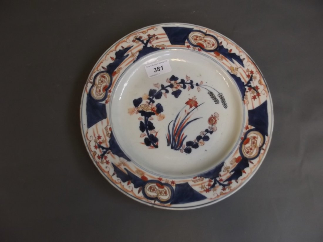 An C18th Japanese blue, white, red and gilt decorated: An C18th Japanese blue, white, red and gilt decorated dish painted with stylised flowers, 10¾'' high