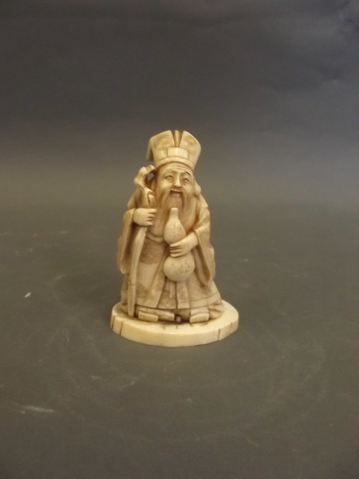 A C19th Chinese carved ivory figure of an Immortal: A C19th Chinese carved ivory figure of an Immortal holding a staff and a gourd, signed, 4'' high