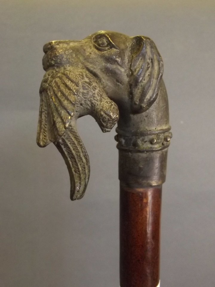 A bronze handled walking stick in the form of a gun dog: A bronze handled walking stick in the form of a gun dog with a pheasant in its mouth, 35¾'' long