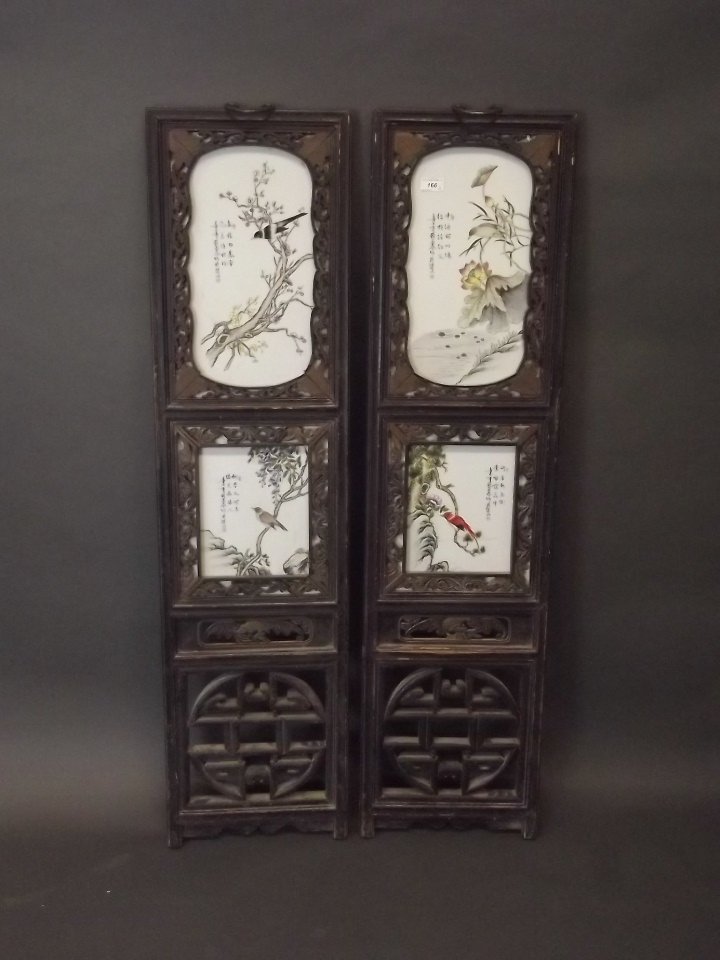 A pair of Chinese porcelain plaques depicting birds: A pair of Chinese porcelain plaques depicting birds amongst blossom, each panel with a verse, mounted in a carved and pierced hardwood frame, 13'' x 51''
