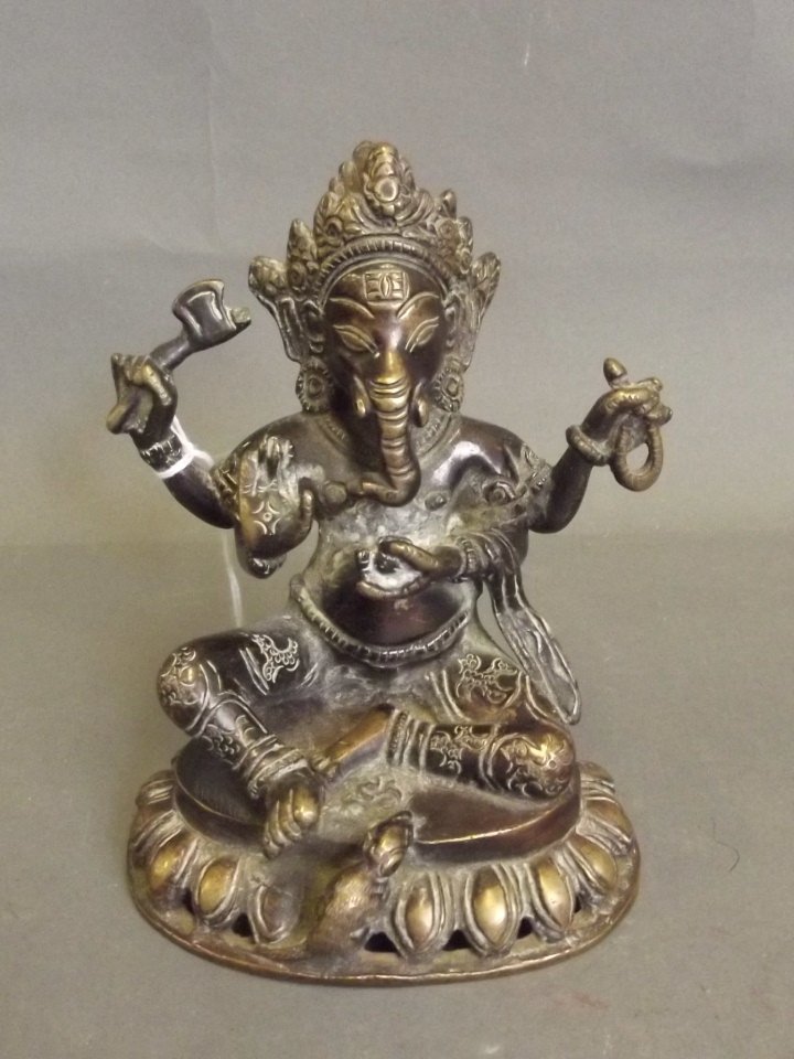 A late C19th/early C20th Indian bronze figure of Ganesh: A late C19th/early C20th Indian bronze figure of Ganesh seated on a lotus throne, 6'' high