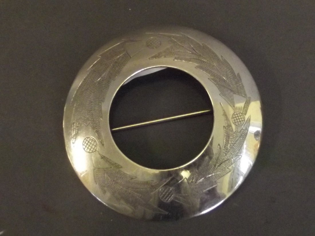 A Hallmarked silver Sash brooch decorated with: A Hallmarked silver Sash brooch decorated with thistles, Birmingham 1960, 3¼'' diameter