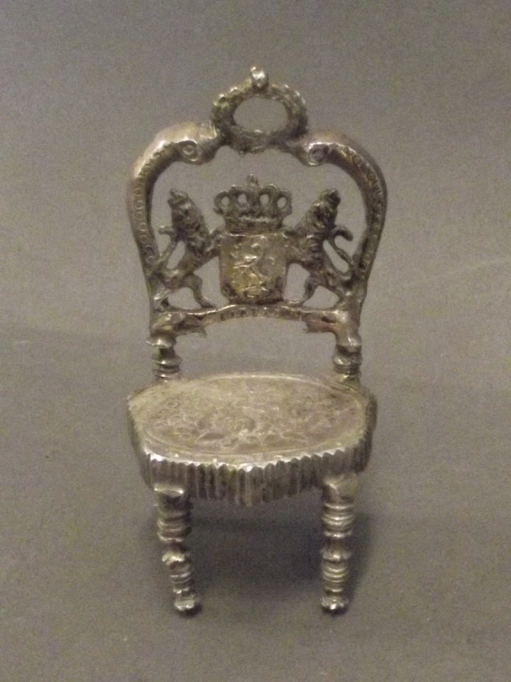 A small miniature Continental silver throne chair: A small miniature Continental silver throne chair decorated with the Royal Coat of Arms, 32g