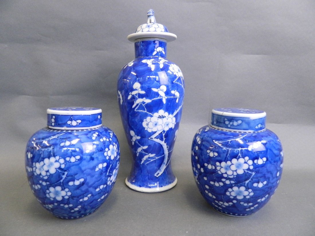 A pair of Chinese ginger jars and covers decorated with: A pair of Chinese ginger jars and covers decorated with prunus pattern, and a similar vase and covers, 13'' high