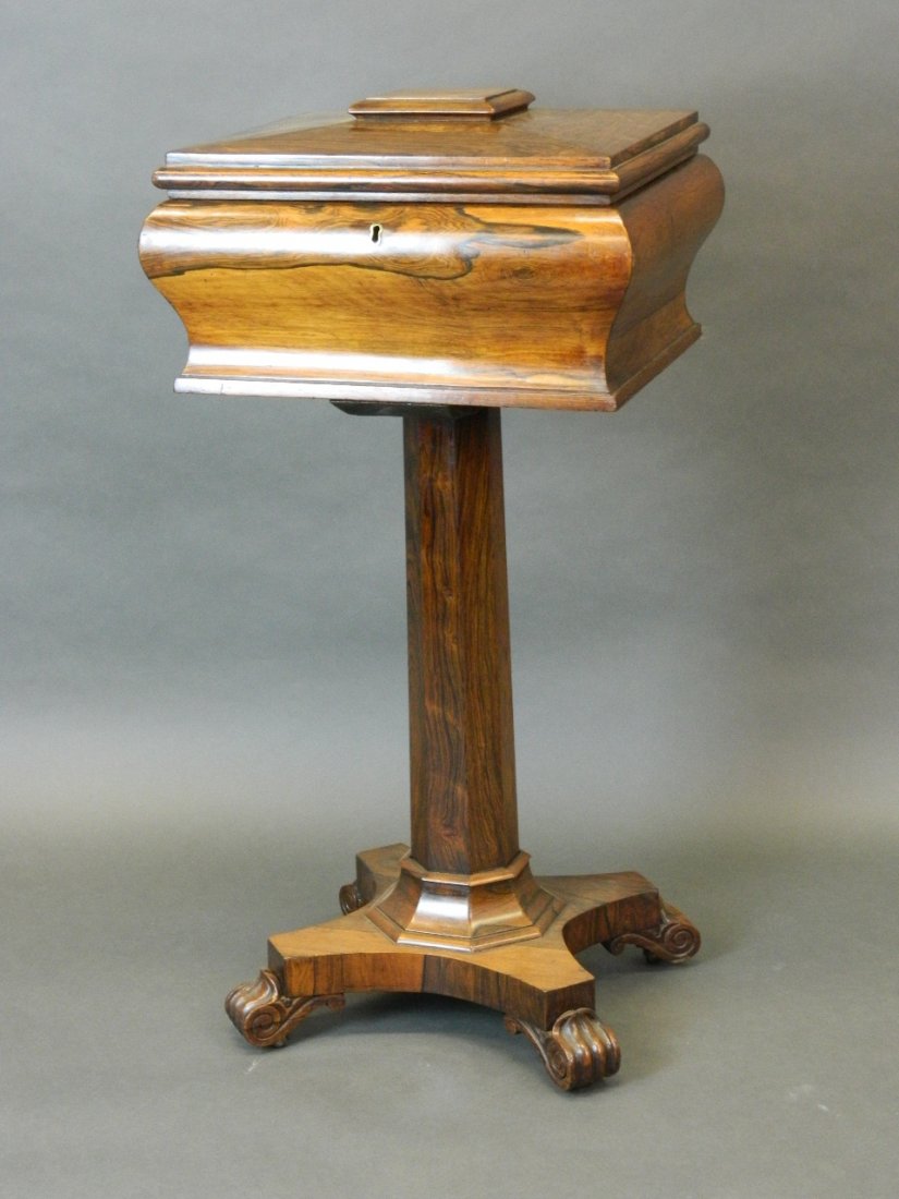 A late Regency rosewood teapoy fitted with four tea: A late Regency rosewood teapoy fitted with four tea canisters, on an octagonal stem and platform base, 16¾'' x 14½'', 34'' high