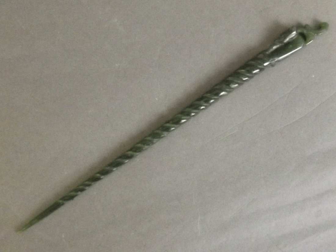 A Chinese green jade hairpin with carved dragon and: A Chinese green jade hairpin with carved dragon and spiral decoration, 9½'' long