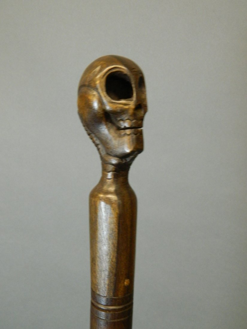 A walking stick with a carved skull handle, 36½'' long: A walking stick with a carved skull handle, 36½'' long