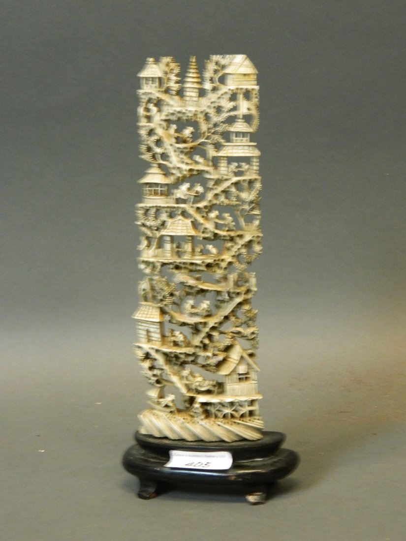 A C19th Cantonese pierced and carved ivory ornament,: A C19th Cantonese pierced and carved ivory ornament, the decoration depicting travellers, mounted on a wooden base, 11'' high (AF repaired)