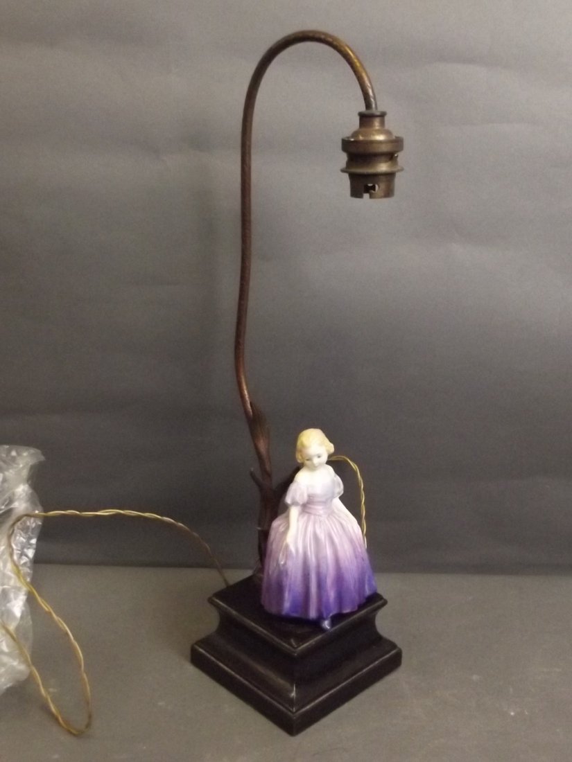 A Doulton porcelain figure of a girl wearing a purple: A Doulton porcelain figure of a girl wearing a purple dress mounted on a lamp base, 16¼'' high