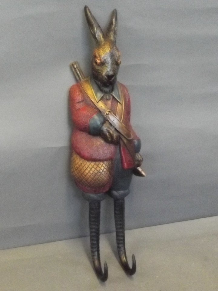 A carved wood painted coat hook in the form of a: A carved wood painted coat hook in the form of a hunting hare, 19'' long