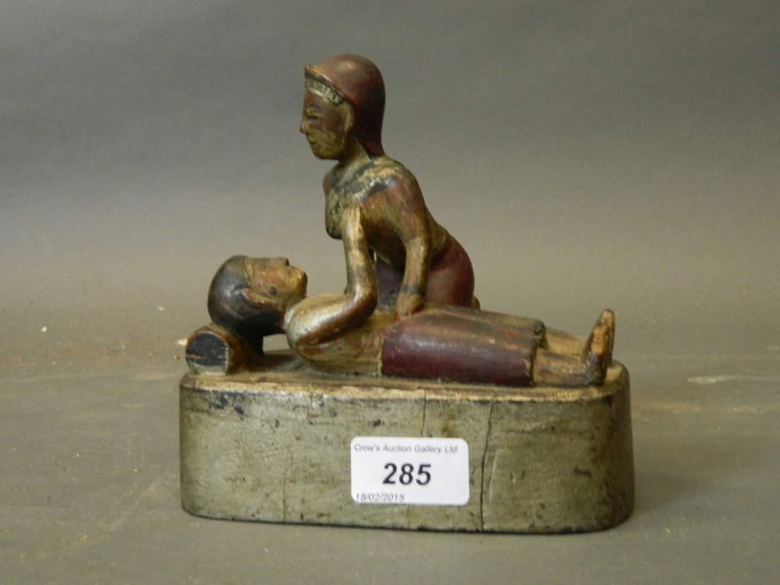 A C19th Eastern naïve carved silver leafed and painted: A C19th Eastern naïve carved silver leafed and painted wood figure group of a courting couple, 6½'' high