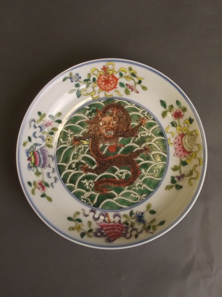 A Chinese porcelain shallow dish painted in coloured: A Chinese porcelain shallow dish painted in coloured enamels with a central dragon, reign mark to base, 7¼'' diameter