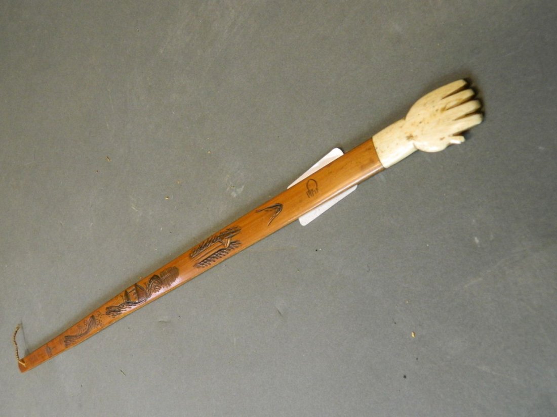 A Chinese bamboo back scratcher with a bone top carved: A Chinese bamboo back scratcher with a bone top carved in the form of a hand, 17½'' long