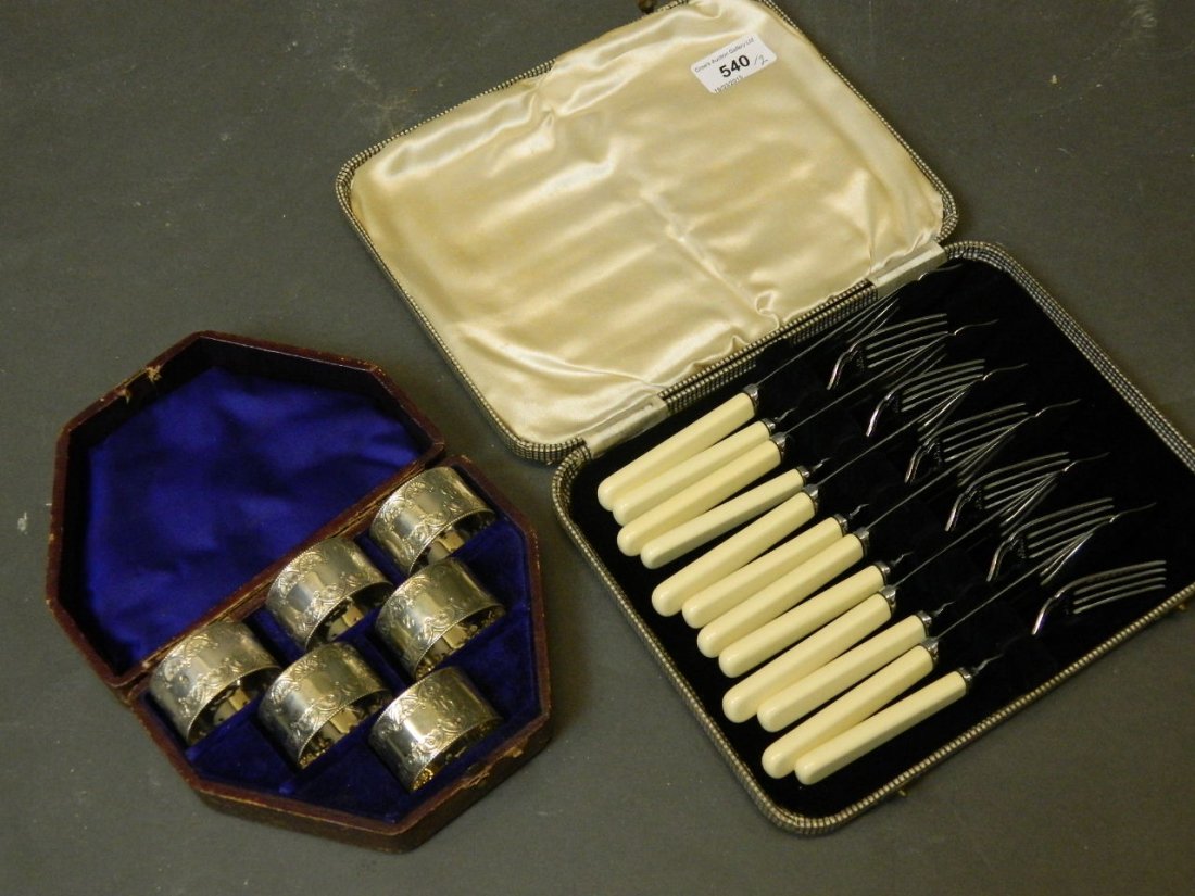 A cased set of six silver plated napkin rings and a set: A cased set of six silver plated napkin rings and a set of fish knives and forks