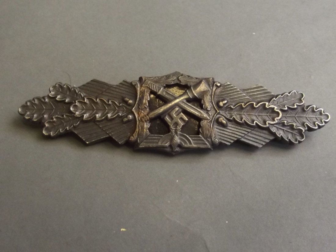 A bronze WWII German military close combat clasp badge,: A bronze WWII German military close combat clasp badge, inscribed verso 'Fec. W.E. Peekhaus, Berlin', and 'Ausf Ag. M.U.K. Gablonz', 4'' long