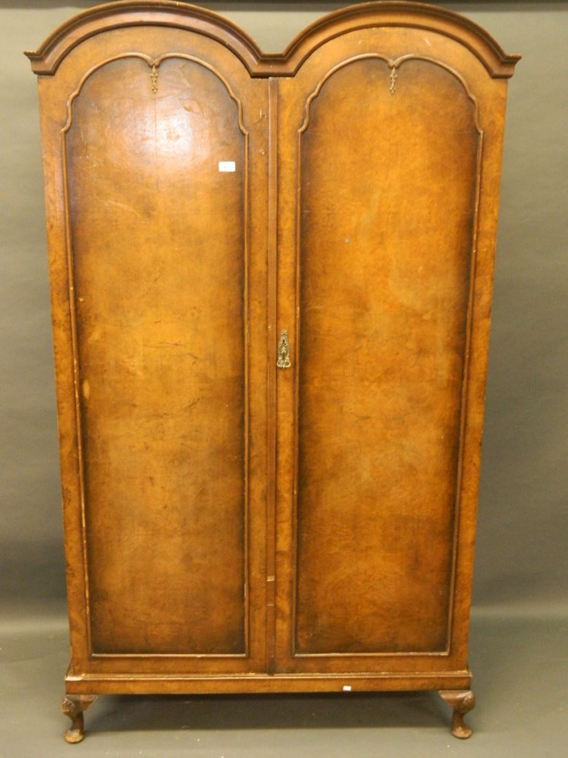 A 1930s double dome topped figured walnut wardrobe on a: A 1930s double dome topped figured walnut wardrobe on a cabriole legged base, labelled 'W. Spriggs & Co. Ltd.', 78'' x 20'' x 46''