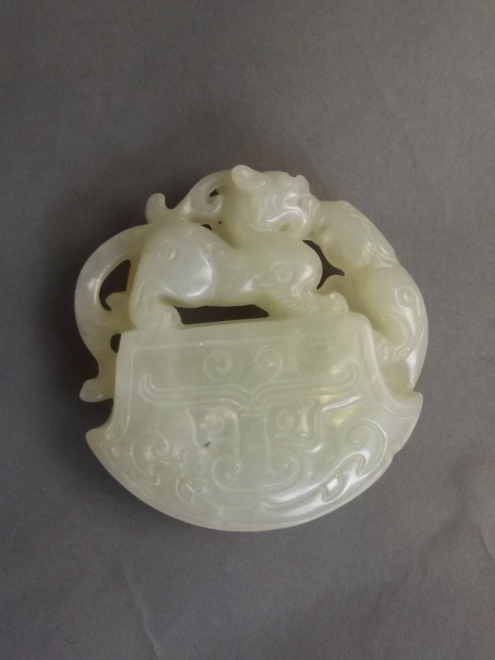 A Chinese celadon jade circular pendant with carved (1 of 2)