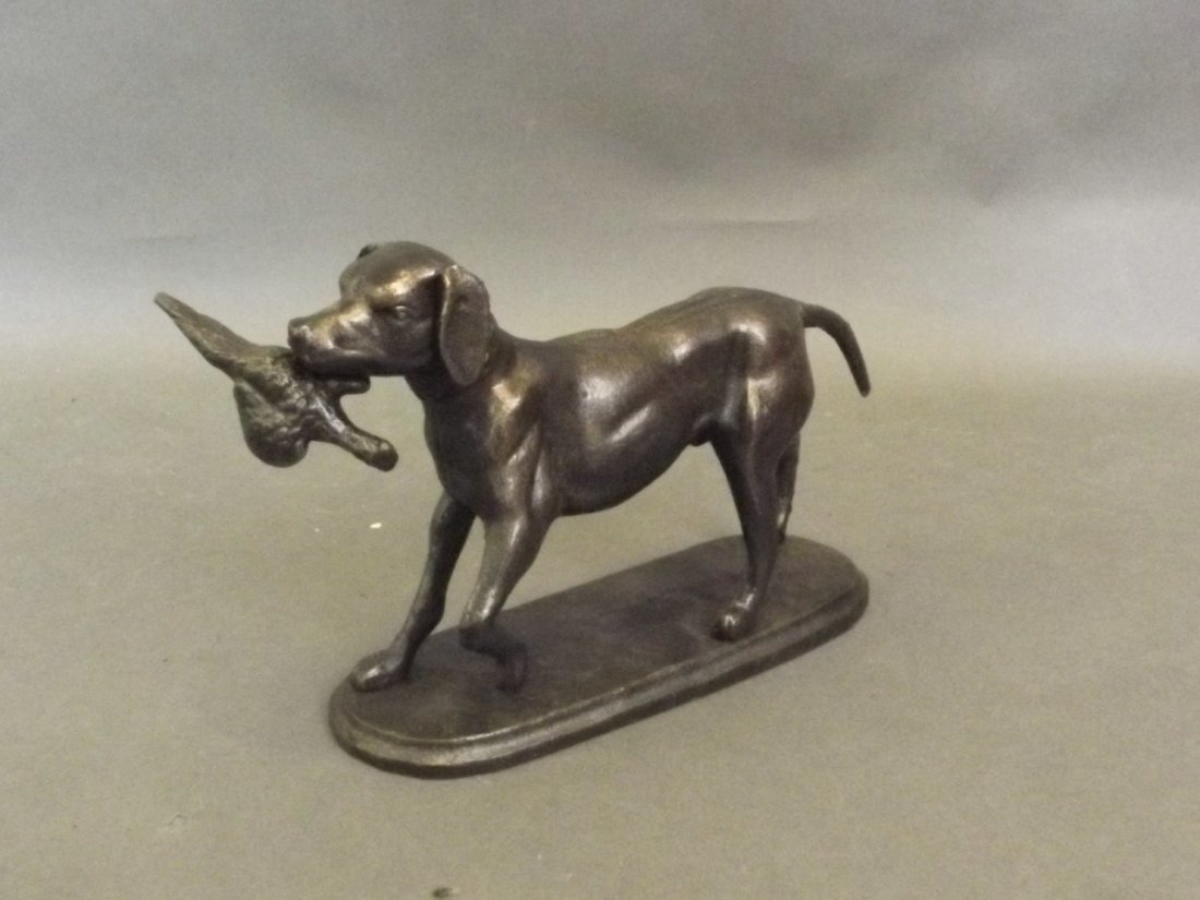 A cast metal door stop in the form of a gun dog with: A cast metal door stop in the form of a gun dog with game bird, 8½'' long