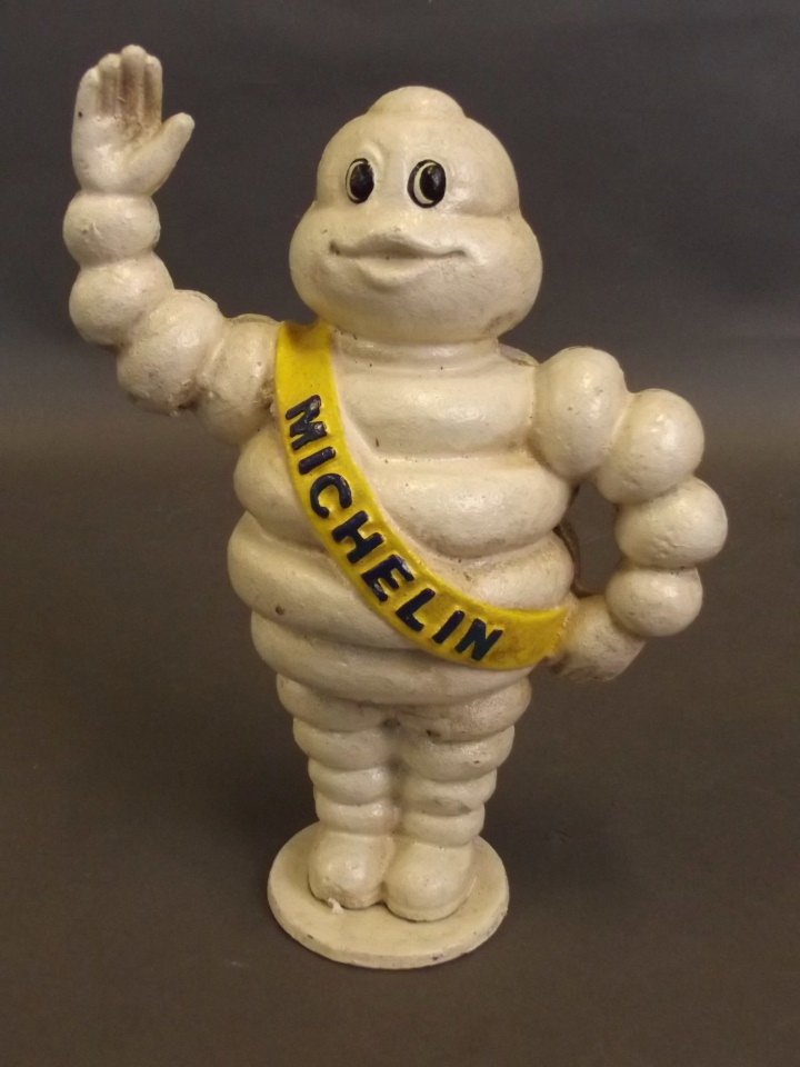 A painted cast metal novelty moneybox in the form of: A painted cast metal novelty moneybox in the form of the Michelin Man, 8½'' high