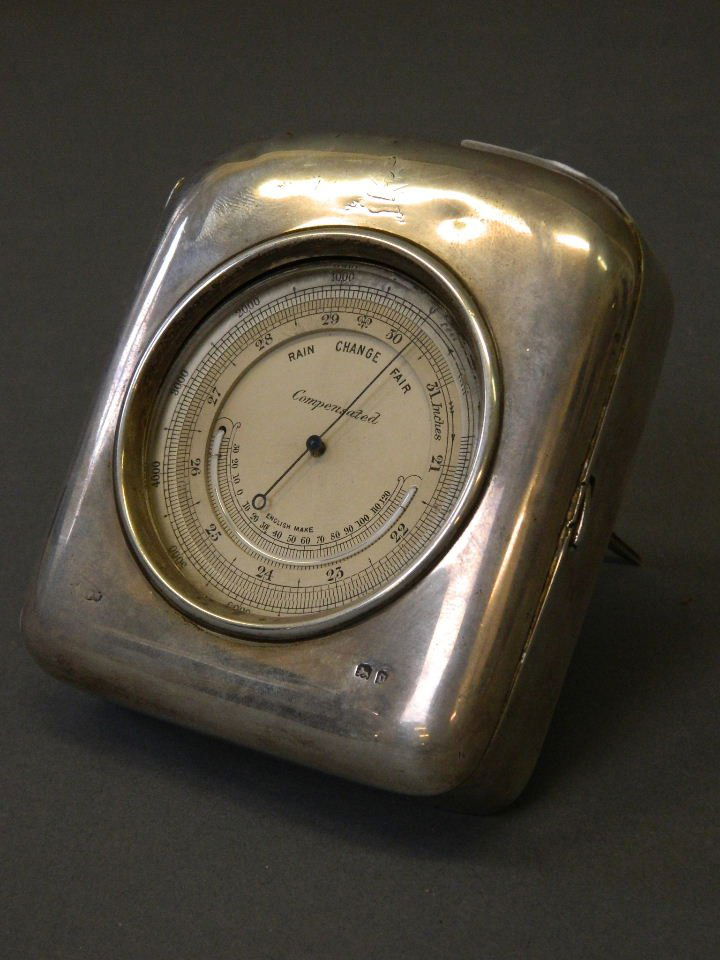 A Hallmarked silver desk barometer with retailer's: A Hallmarked silver desk barometer with retailer's stamp 'Finnigans of Bond Street', maker's mark WFW (William Frederick Wright), London 1919, 4'' high