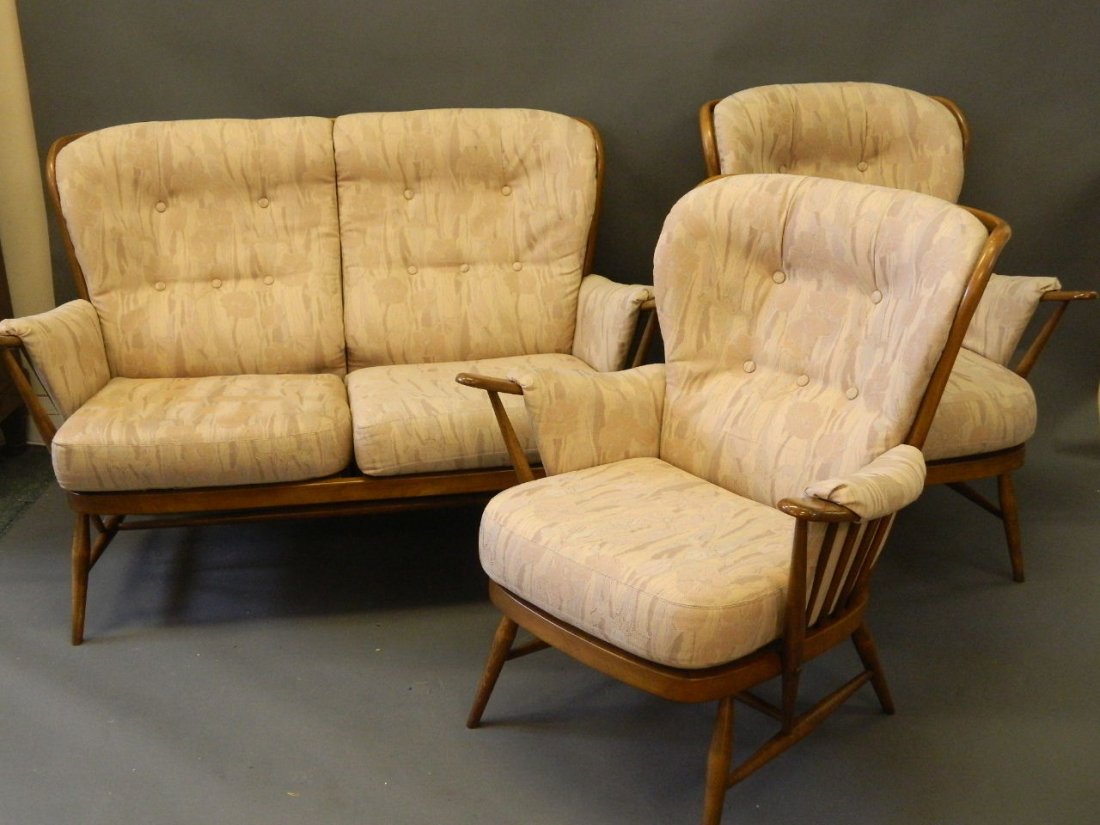 An Ercol stained beech two seater settee with two: An Ercol stained beech two seater settee with two matching armchairs, 36'' high