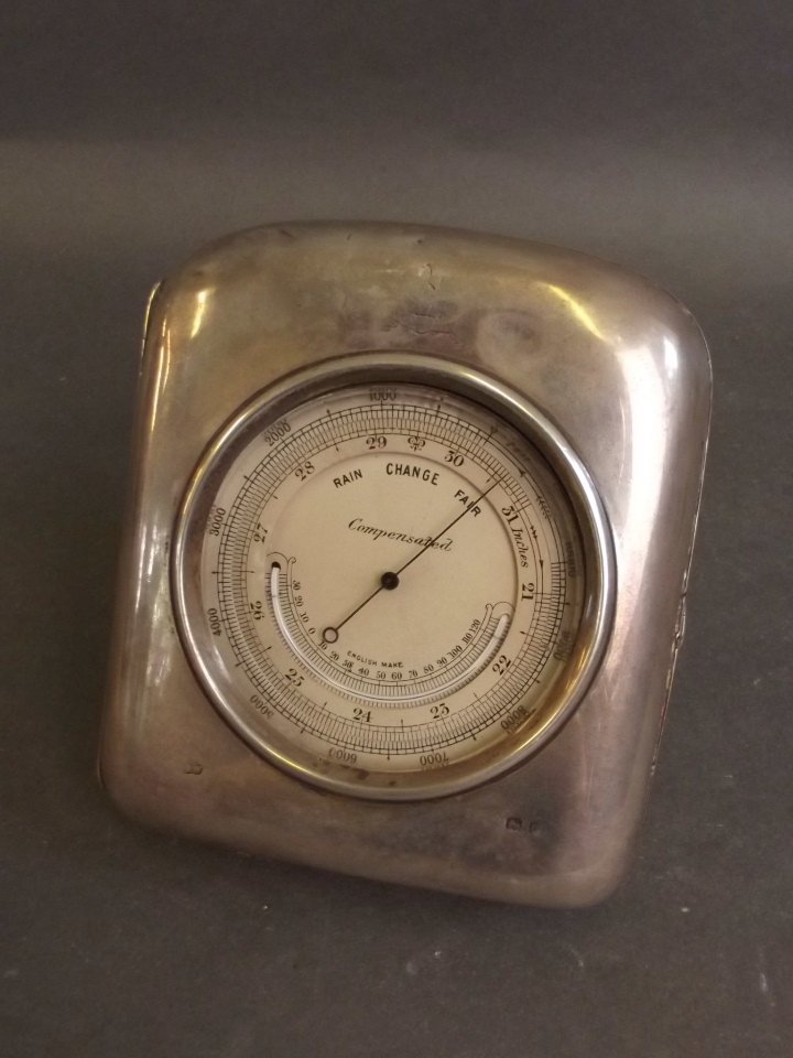 A Hallmarked silver desk barometer with retailer's: A Hallmarked silver desk barometer with retailer's stamp 'Finnigans of Bond Street', maker's mark WFW (William Frederick Wright), London 1919, 4½'' high