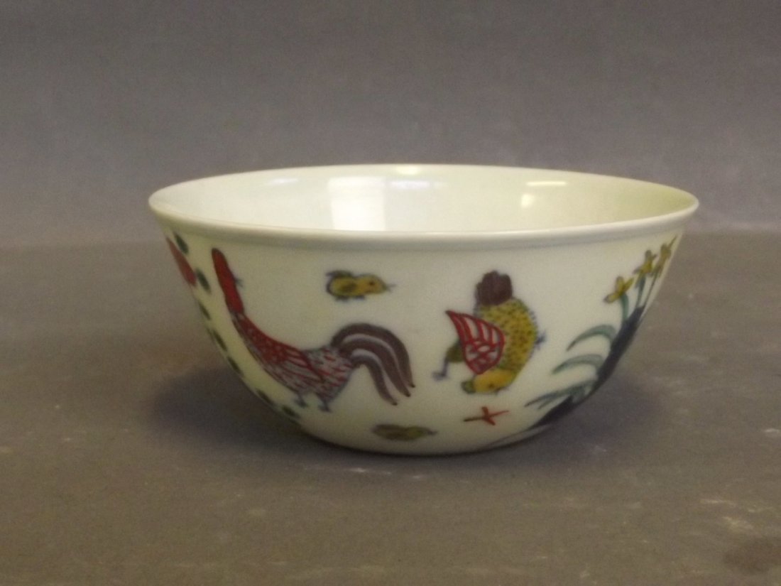 A Chinese Doucai tea bowl decorated with a chicken and: A Chinese Doucai tea bowl decorated with a chicken and flowers, 3'' diameter