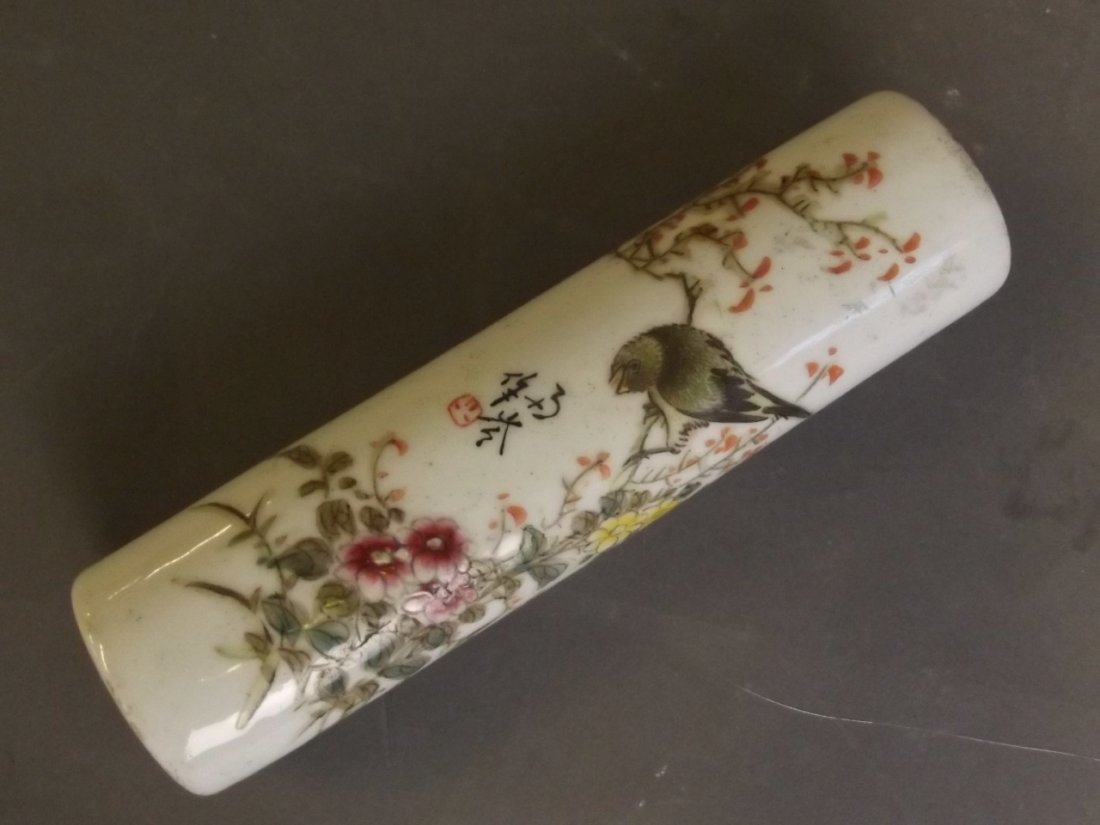 A Chinese porcelain wrist rest with pierced ends and: A Chinese porcelain wrist rest with pierced ends and painted enamel decoration of a bird perched on a flowering branch, 6'' long