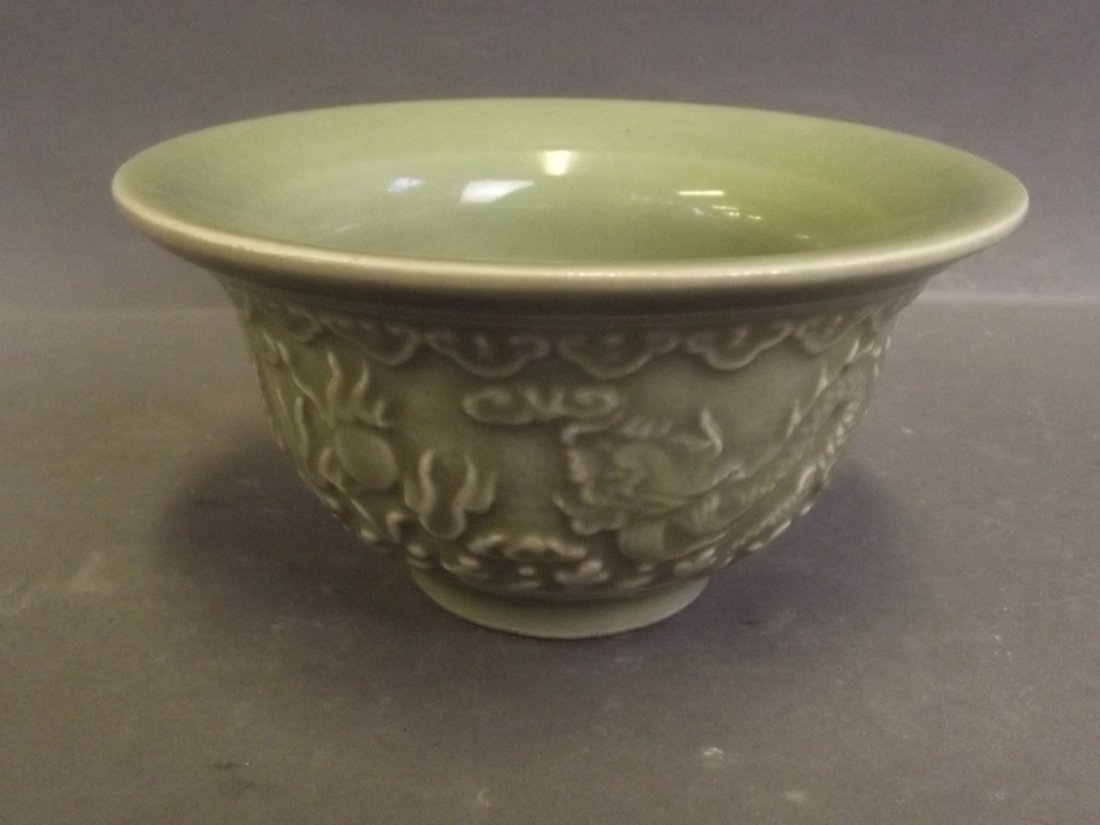 A Chinese olive green ground bowl with relief twin: A Chinese olive green ground bowl with relief twin dragon and flaming pearl decoration, 4'' diameter